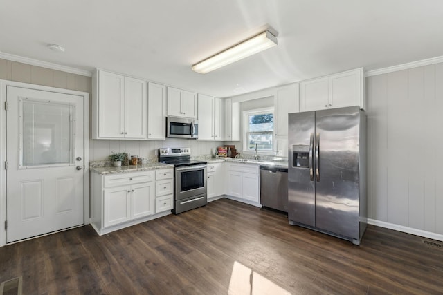 kitchen with stainless steel appliances, visible vents, white cabinets, ornamental molding, and dark wood-style floors