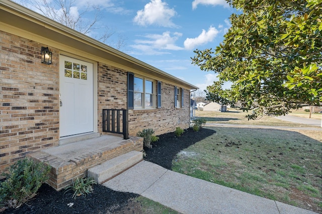 view of exterior entry with brick siding