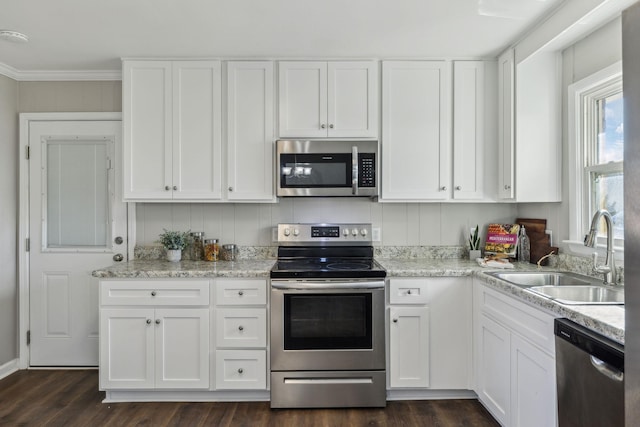 kitchen with white cabinetry, crown molding, appliances with stainless steel finishes, and a sink