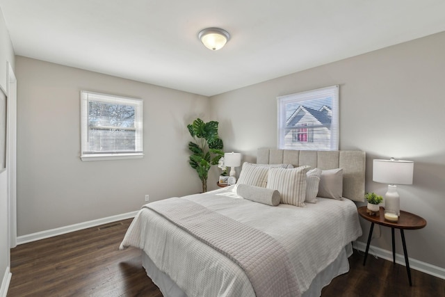 bedroom featuring visible vents, baseboards, and wood finished floors