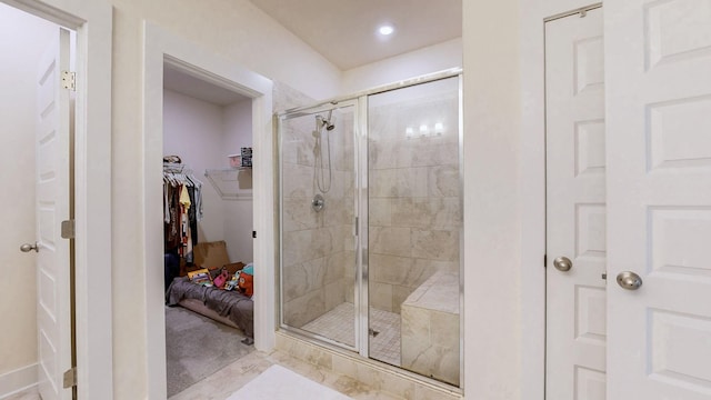 bathroom featuring a shower stall and a walk in closet