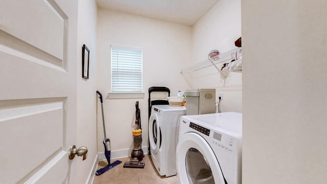 laundry room with laundry area, light tile patterned floors, baseboards, and washer and clothes dryer