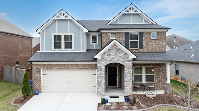 craftsman house with concrete driveway, brick siding, roof with shingles, and fence