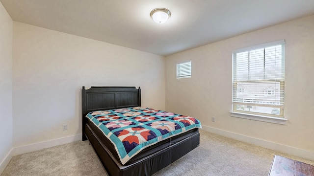 bedroom with light carpet and baseboards