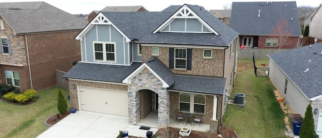 view of front facade featuring driveway, a garage, fence, cooling unit, and a front lawn