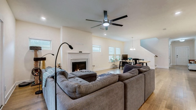 living room with light wood-style floors, recessed lighting, baseboards, and a premium fireplace