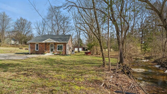 view of front facade with brick siding and a front lawn