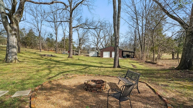 view of yard featuring an outbuilding, an outdoor fire pit, an outdoor structure, and a detached garage