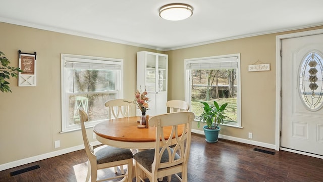 dining room featuring crown molding, wood finished floors, visible vents, and baseboards