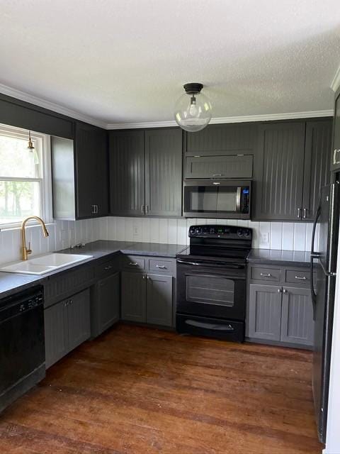 kitchen featuring crown molding, decorative backsplash, dark wood-type flooring, a sink, and black appliances