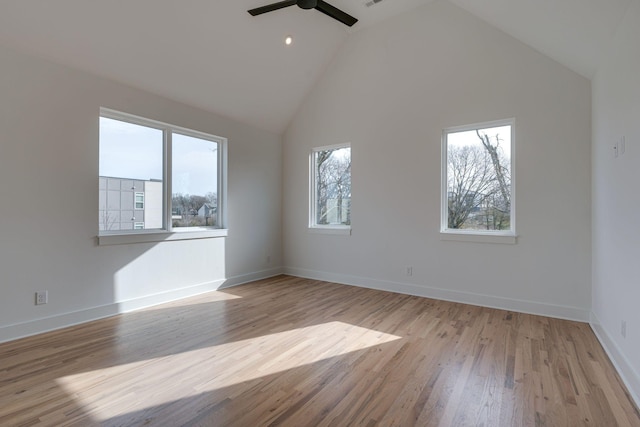 unfurnished room featuring visible vents, baseboards, ceiling fan, wood finished floors, and high vaulted ceiling