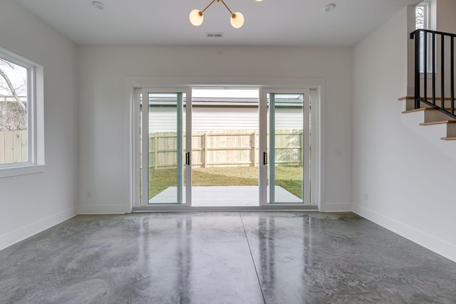 unfurnished room featuring finished concrete floors, visible vents, baseboards, and stairs