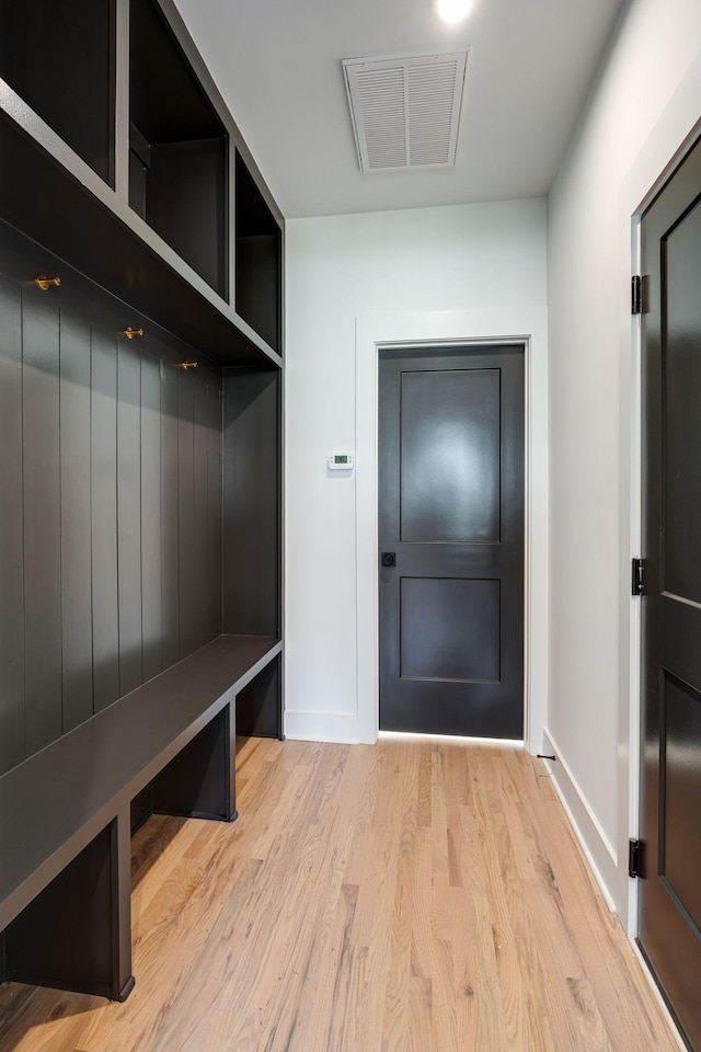 mudroom with wood finished floors, visible vents, and baseboards