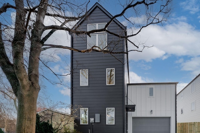 exterior space with a garage, fence, and board and batten siding