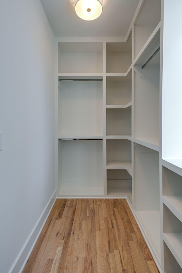 walk in closet with wood finished floors