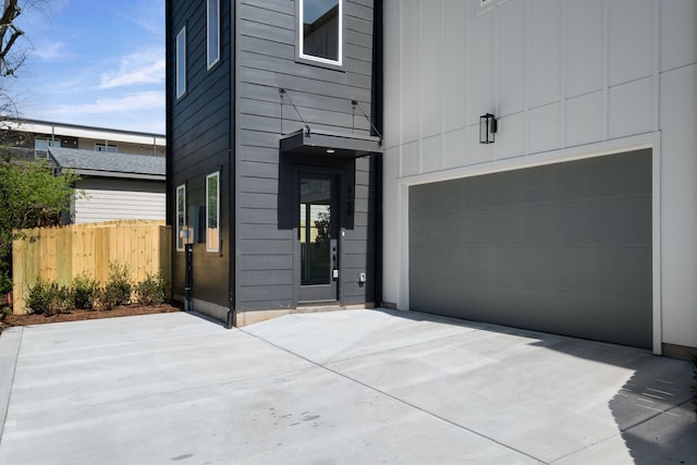 view of front of house with an attached garage, fence, and board and batten siding