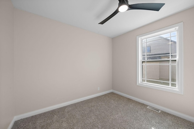 carpeted spare room with a ceiling fan, visible vents, and baseboards