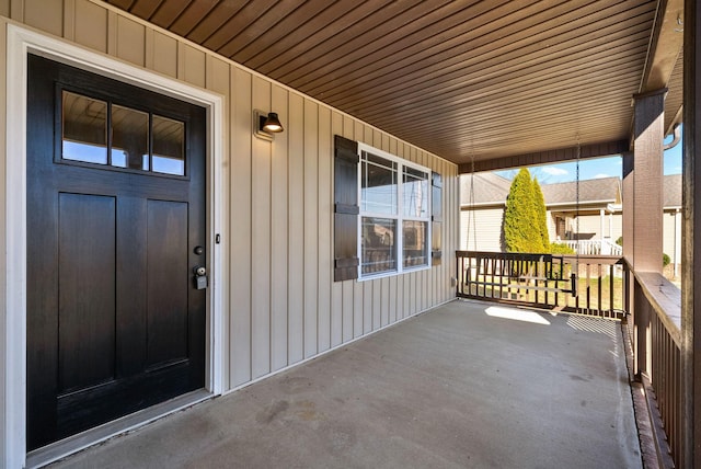 entrance to property featuring board and batten siding and covered porch