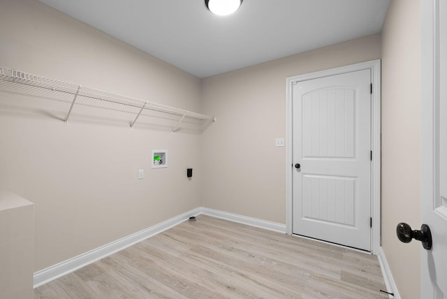 laundry area featuring laundry area, baseboards, and light wood-style floors