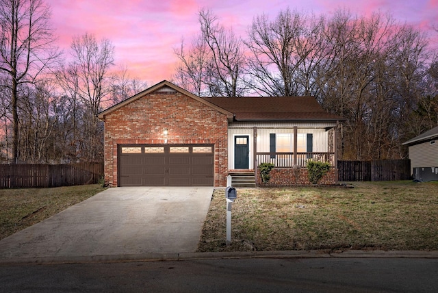 ranch-style house with an attached garage, a yard, driveway, and brick siding