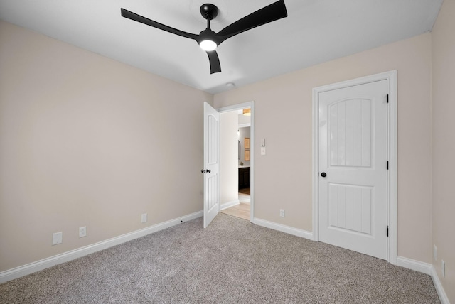 unfurnished bedroom featuring baseboards, a ceiling fan, and light colored carpet