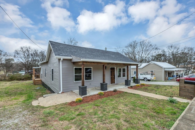 bungalow featuring covered porch, a shingled roof, and a front lawn