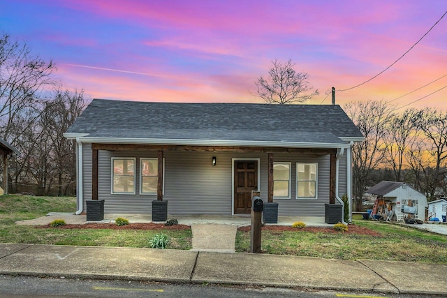 bungalow-style house with a shingled roof and covered porch