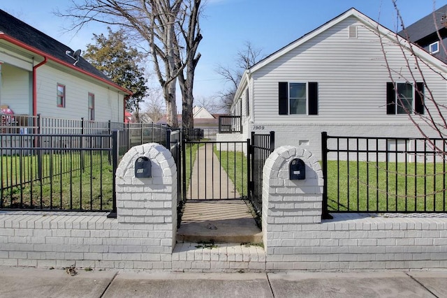 view of gate with a fenced front yard and a lawn