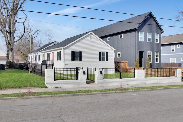 view of front facade featuring a fenced front yard and a front lawn