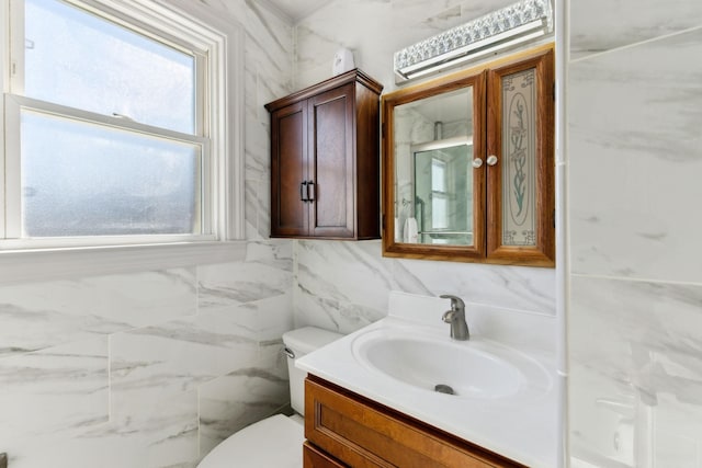 bathroom with tile walls, vanity, and toilet