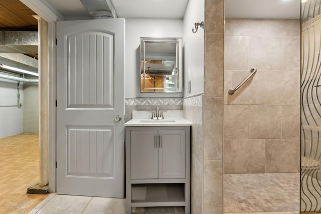 bathroom featuring tile patterned flooring, tile walls, vanity, and walk in shower