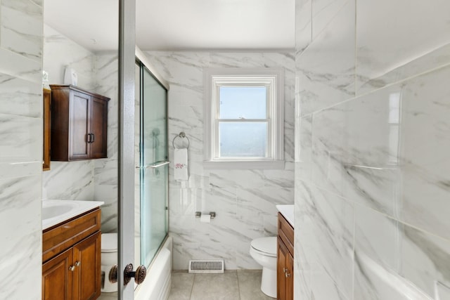 full bath featuring toilet, visible vents, tile walls, and vanity