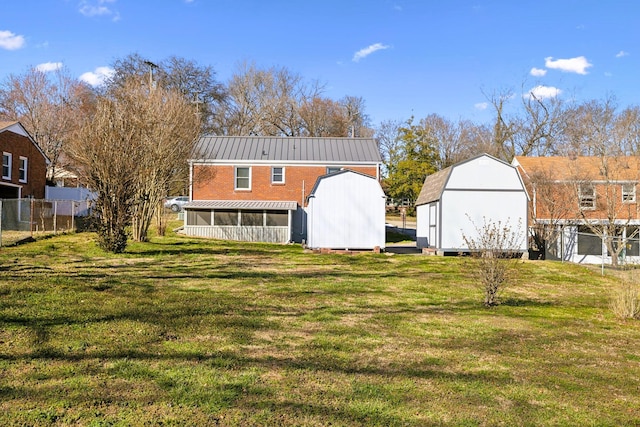 back of property featuring a storage shed, fence, a sunroom, and an outdoor structure