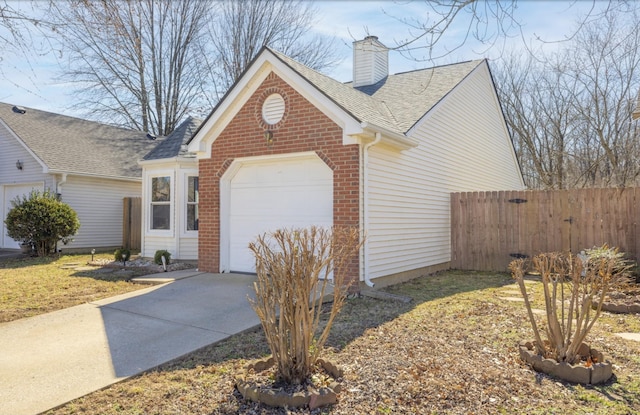 exterior space featuring an attached garage, brick siding, fence, concrete driveway, and a chimney