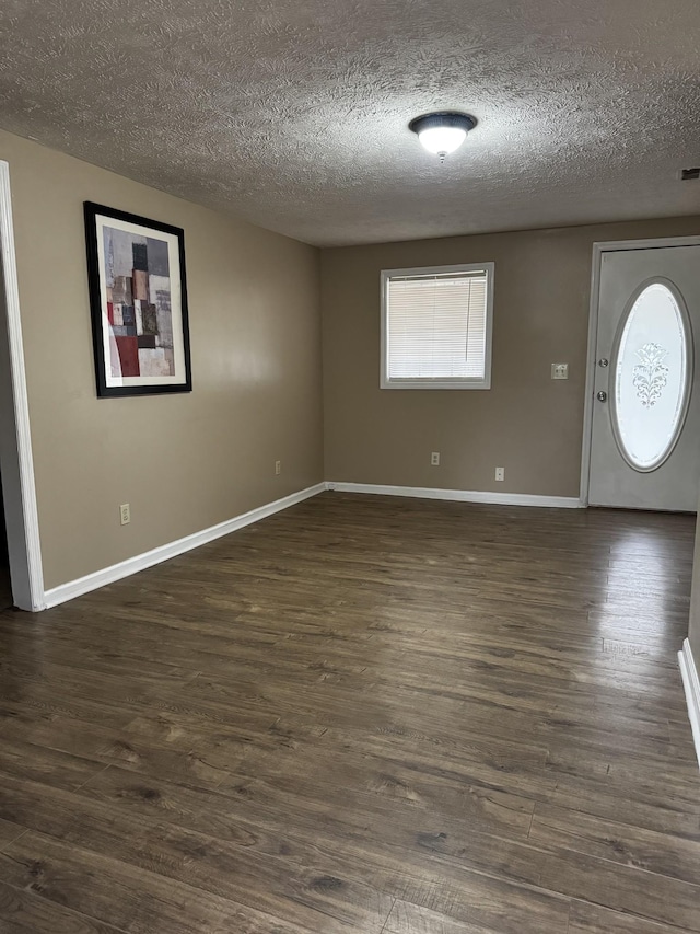 entryway with dark wood-style flooring, a textured ceiling, and baseboards