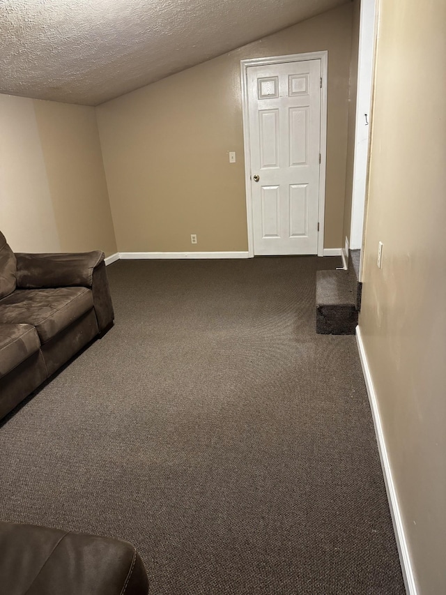 carpeted living room with lofted ceiling, baseboards, and a textured ceiling