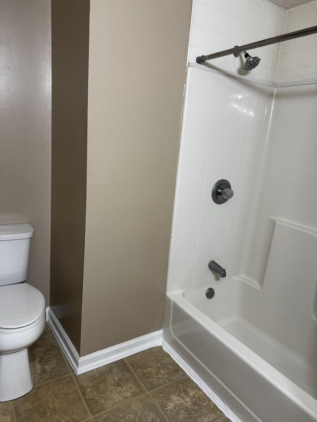 bathroom with toilet, shower / tub combination, baseboards, and tile patterned floors