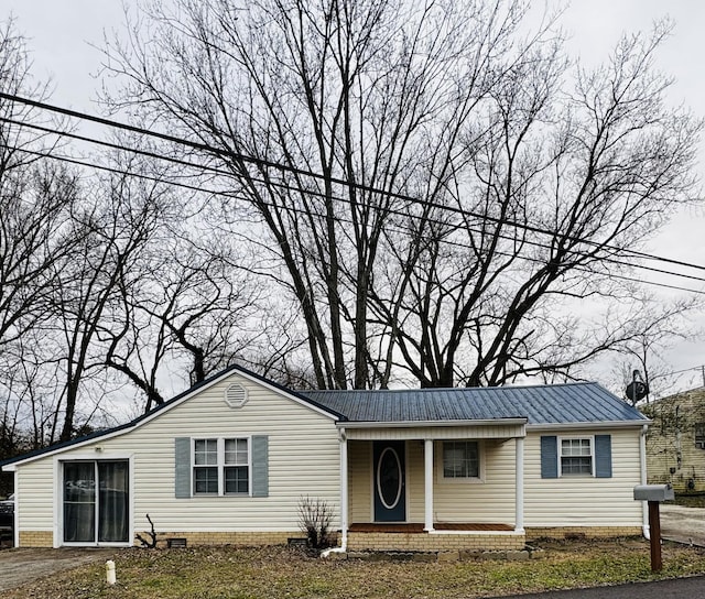 view of front of house featuring covered porch, metal roof, and crawl space