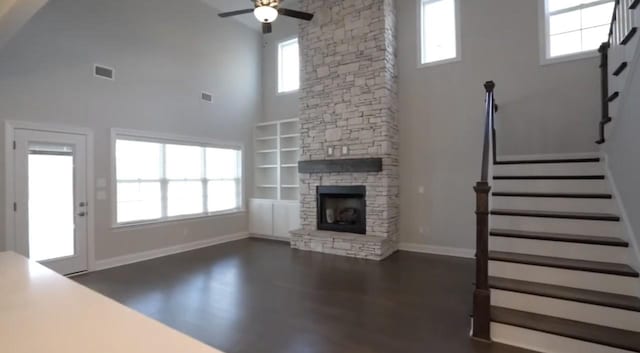 unfurnished living room with a healthy amount of sunlight, visible vents, and stairway