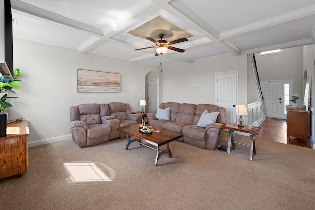 carpeted living area with arched walkways, coffered ceiling, and beamed ceiling