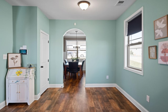 interior space featuring baseboards, dark wood finished floors, visible vents, and a healthy amount of sunlight