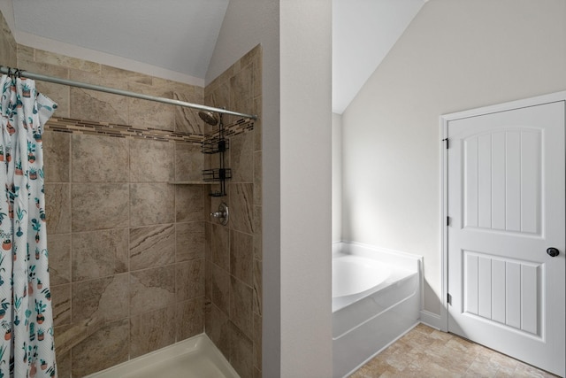 full bathroom with vaulted ceiling, a stall shower, and a bath