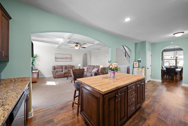 kitchen featuring butcher block countertops, arched walkways, coffered ceiling, and dark wood-type flooring