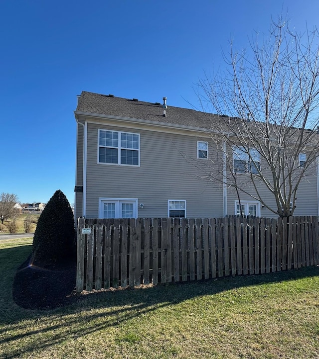 view of side of property with a yard and fence