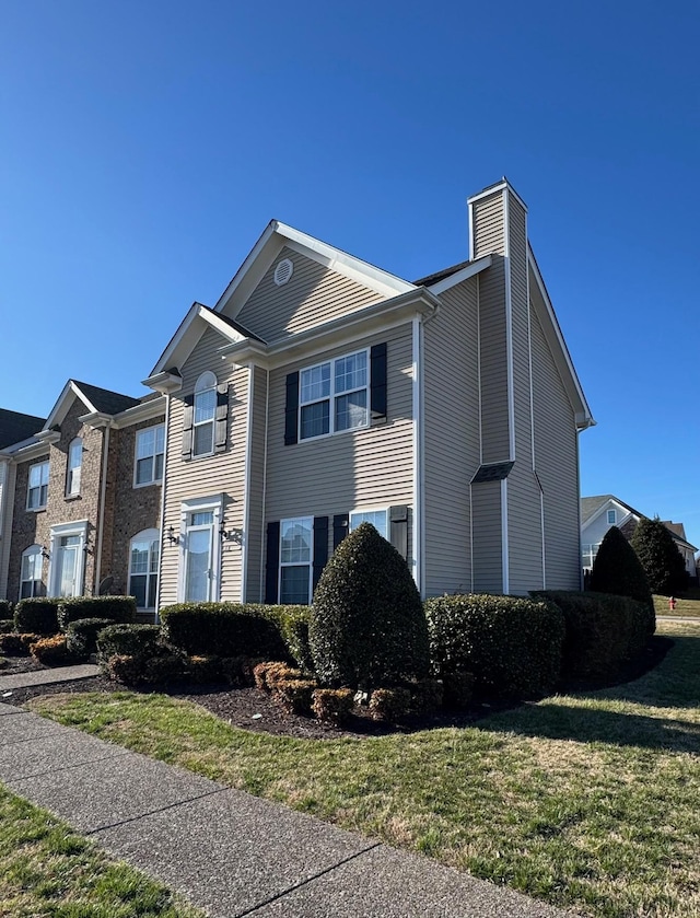 view of front of home featuring a chimney and a front yard