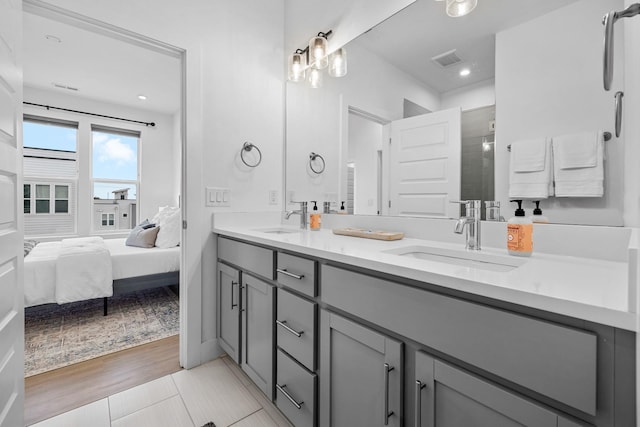 bathroom featuring connected bathroom, visible vents, a sink, and a shower stall