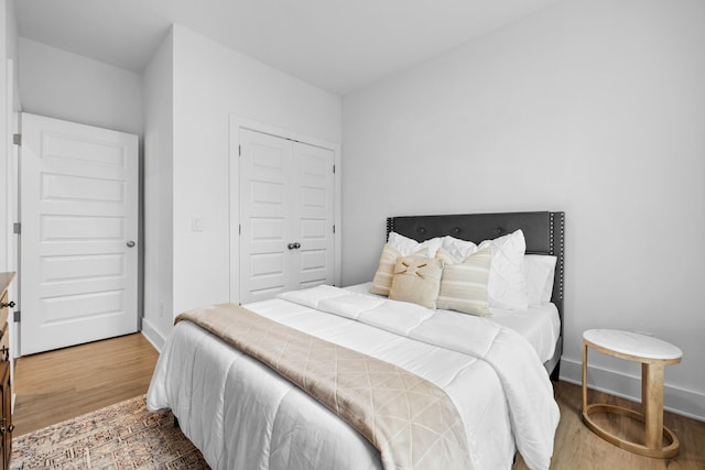 bedroom featuring a closet, baseboards, and wood finished floors