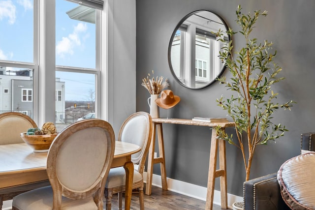 dining space with baseboards and wood finished floors