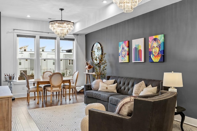 living room with an inviting chandelier, baseboards, wood finished floors, and recessed lighting