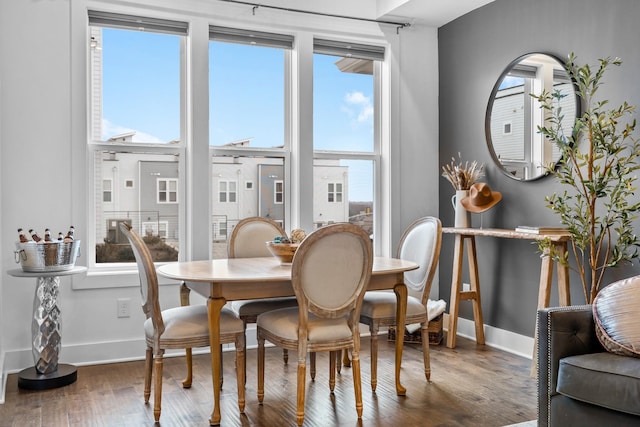 dining space featuring baseboards and wood finished floors